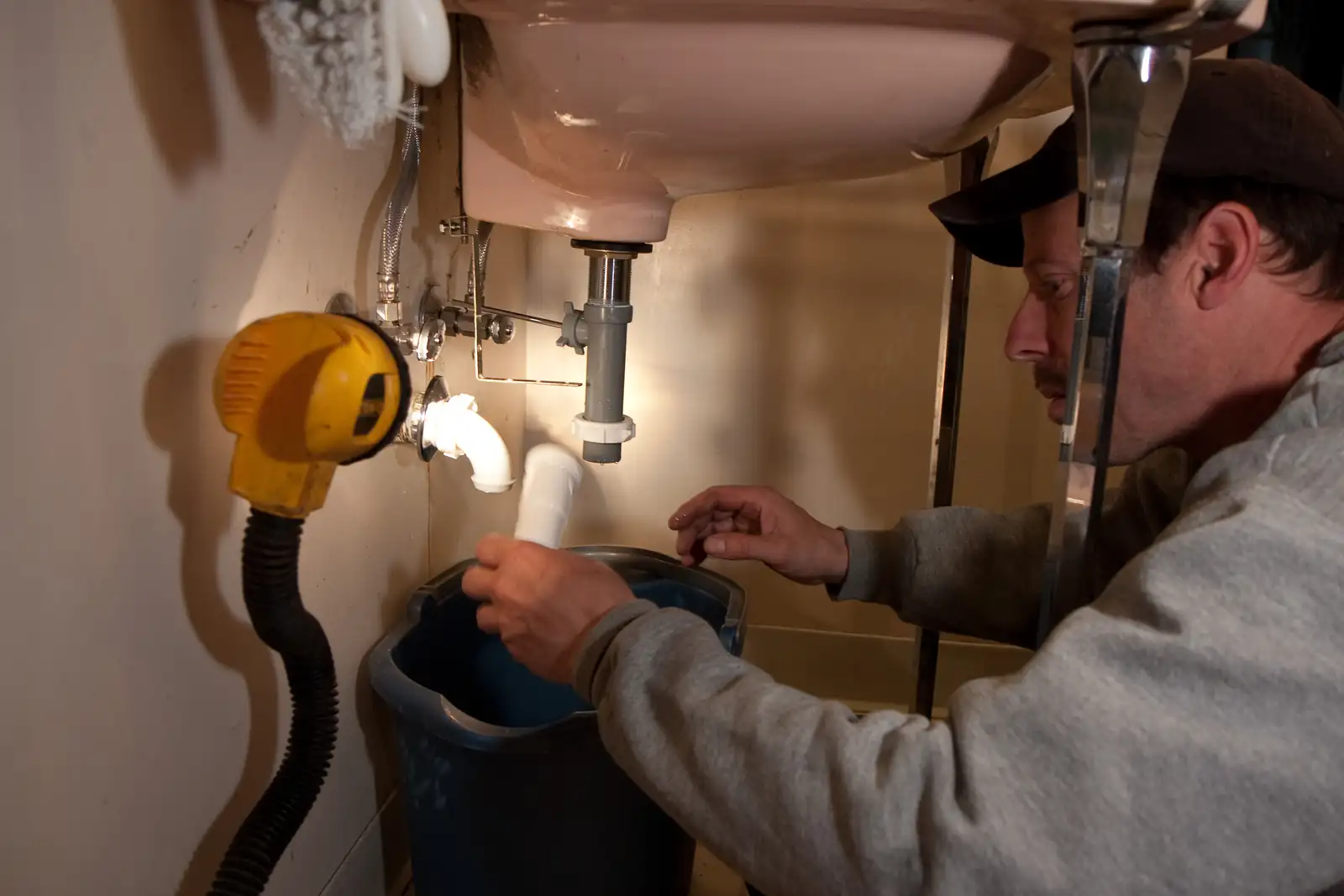 A plumber working under a kitchen sink